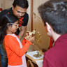 A volunteer shows a child how to use a sextant