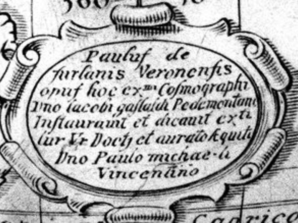 Inscription on the globe, with decorative scrollwork outlining the cartouche