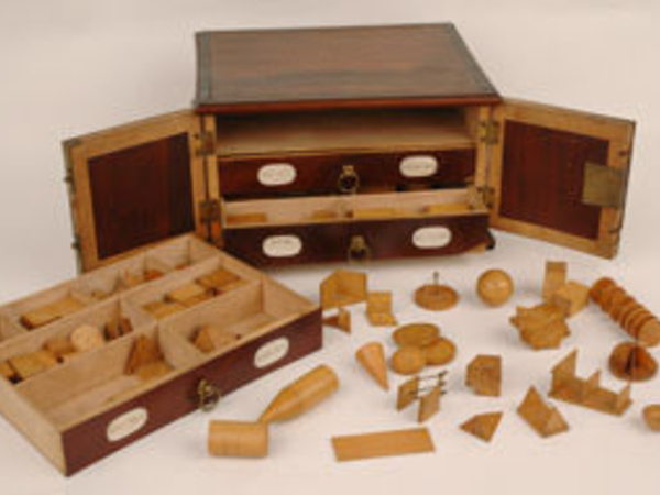 Set of wooden geometric models in a miniature chest of drawers