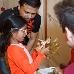 A volunteer shows a child how to use a sextant